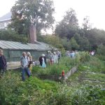 Die Führung im Garten des Trillke Gut, im Hintergrund die Solarmodule auf dem Dach © Tour de Natur